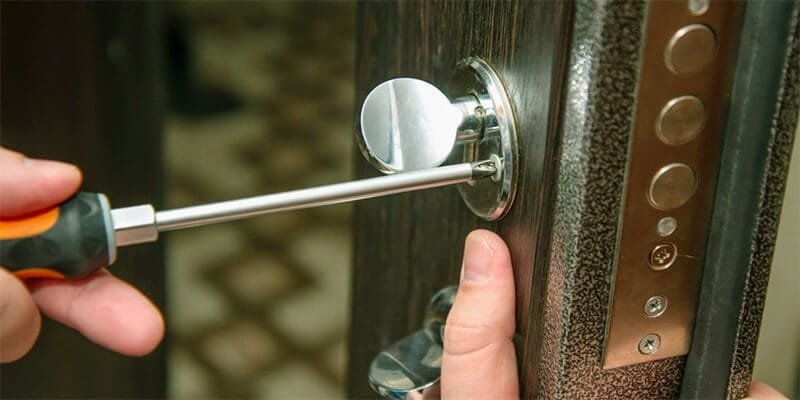Locksmith repairing door lock hardware on site