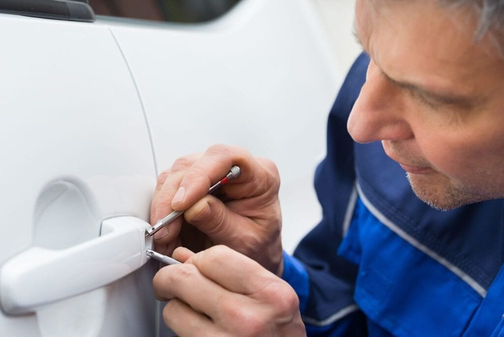 Locksmith unlocking a vehicle door during a lockout