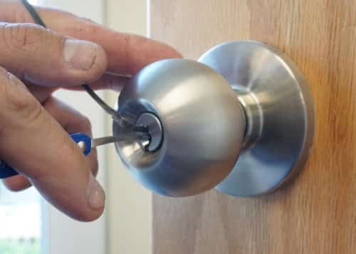 Locksmith picking a door lock during an emergency lockout call in Ballwin, Missouri