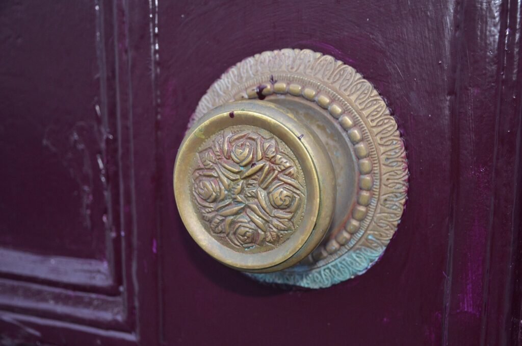 Round brass door knob on a dark painted period front door
