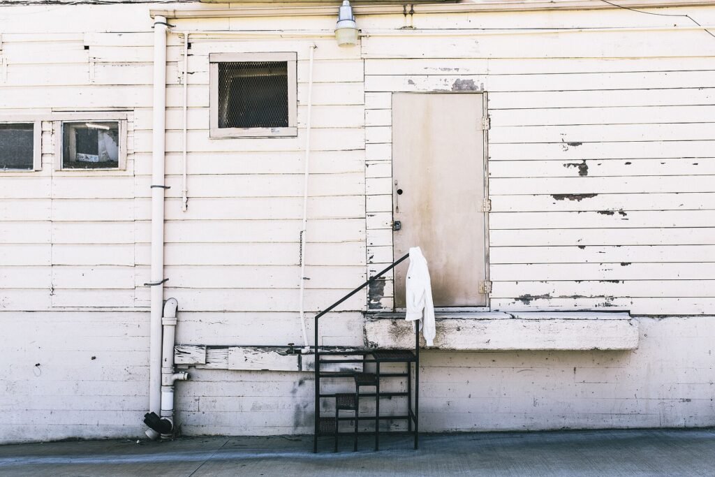 White entry door set into white wooden siding