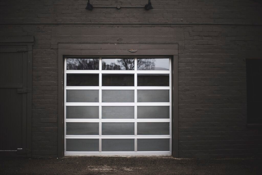 Glass-panel garage door set in a dark wall