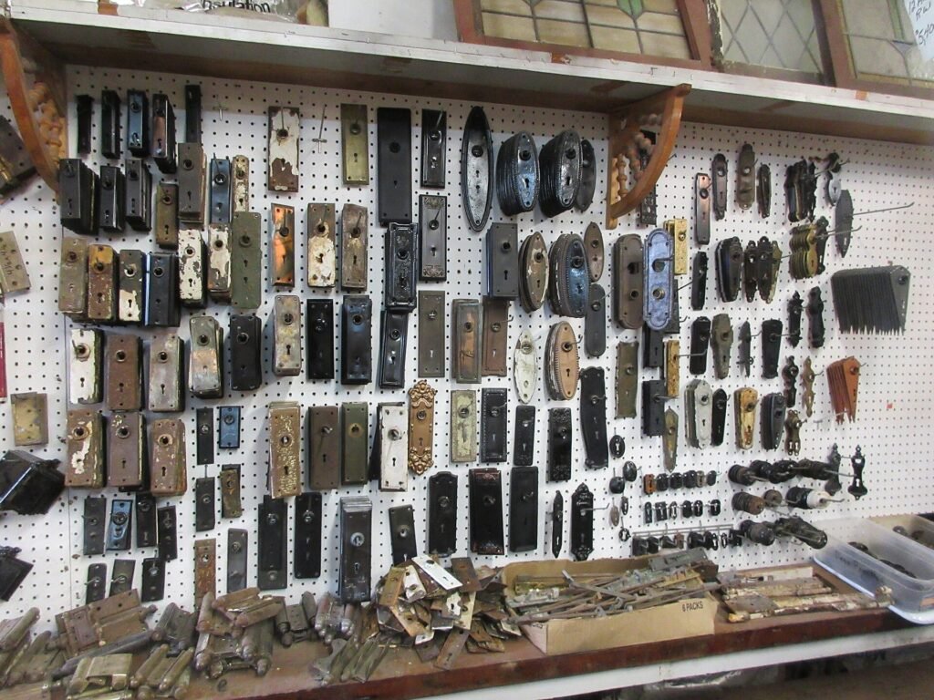 Wall display of old door knob plates and door hardware