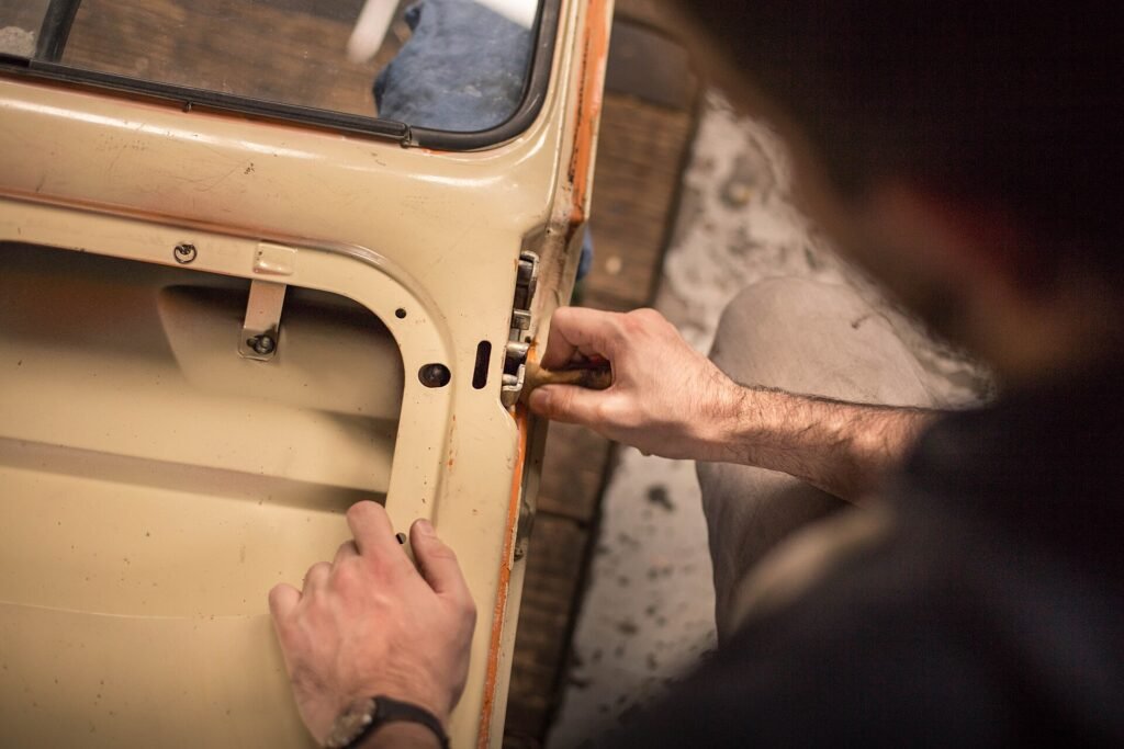 Hands working on a car door lock to open the door